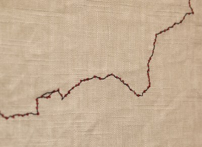 A canvas stitched with red thread.