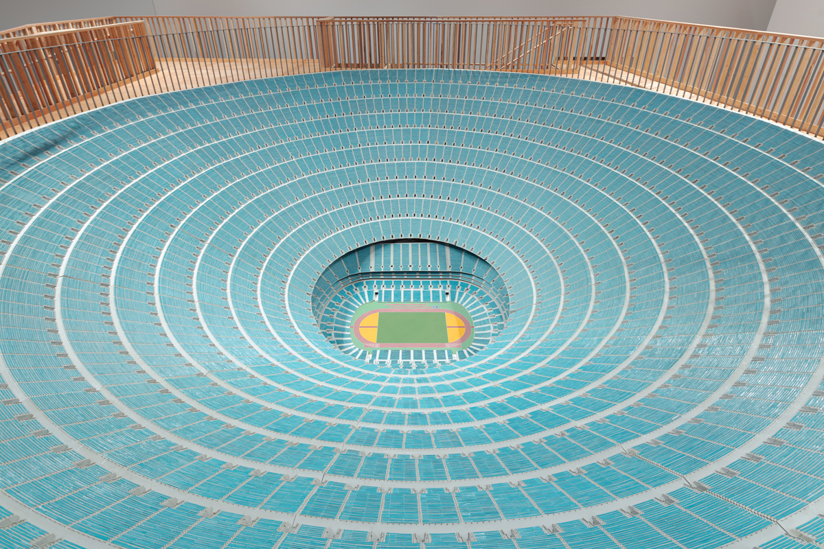 Concentric blue circles surround a football field in a miniature stadium.