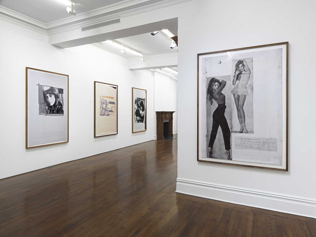 A gallery whose walls are hung with photoworks that feature black-and-white images of women, along with text that is illegible from a distance.
