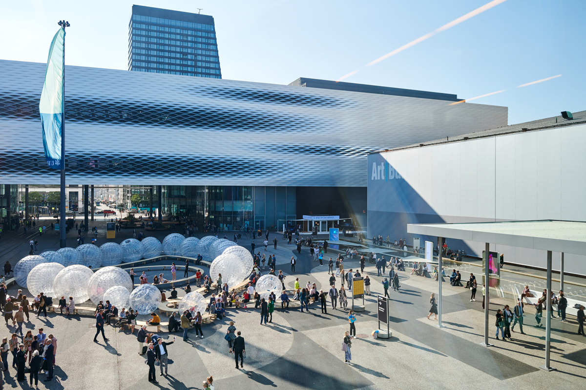 Photograph outside the convention center where Art Basel takes place. Dozens of people are shown in attendance.