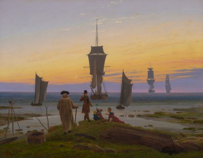A group of people seen from behind, sitting on mossy rocks on a shore at sunset. Ahead of them are ships sailing out to sea.