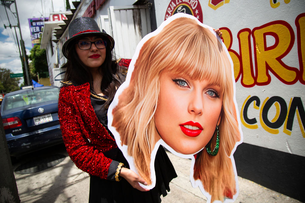 TOPSHOT - A fan of US superstar Taylor Swift holds a poster with the image of a singer before her presentation at the Foro Sol in Mexico City on August 24, 2023. (Photo by Rodrigo Oropeza / AFP) (Photo by RODRIGO OROPEZA/AFP via Getty Images)