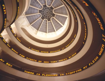 A rotunda with text displayed on screens running up its interior.