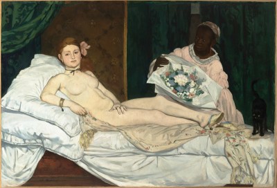 Painting of a naked white woman wearing only shoes, a necklace, and a flower in her hair. She is lounging on a bed and a Black woman stands behind her.