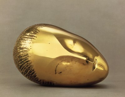 A sculpted head in gold turned on its side.