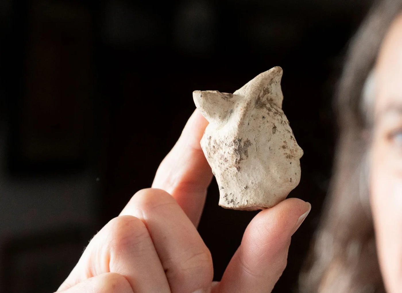 A woman holds the head of a Roman clay figurine depicting the god Mercury recently found at the archaeological site Smallhythe in the English town of Kent.