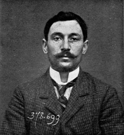 Old-timey mugshot of a man with a moustache.
